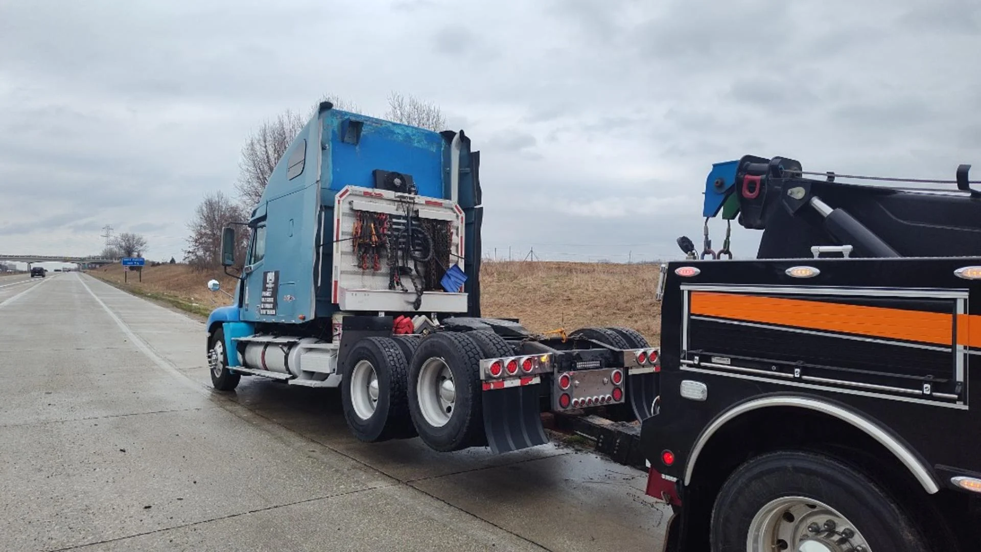 Zielke Towing recovering blue big rig with dead battery near highway in Benton Harbor