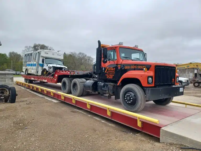 Zielke Towing hauling a damaged bus on lowboy trailer in Benton Harbor, MI