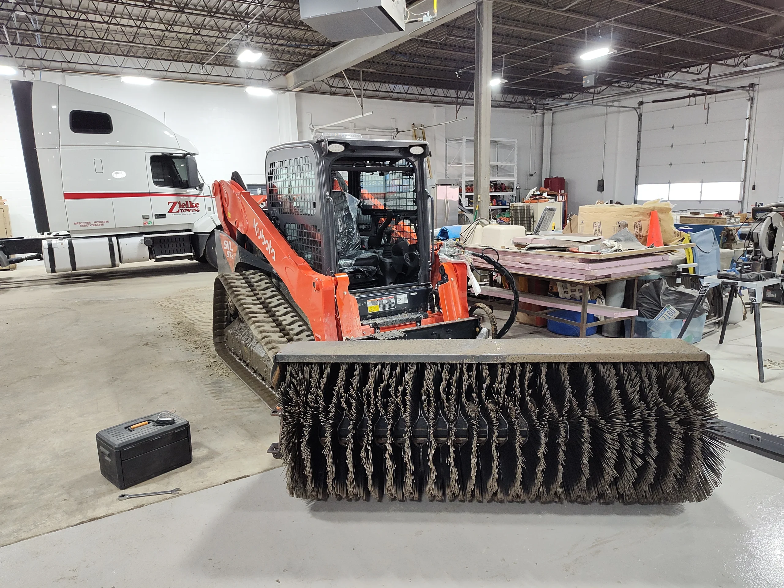 Close-up of Kubota SVL97 skid steer with engine exposed during repair at Zielke Towing & Tire