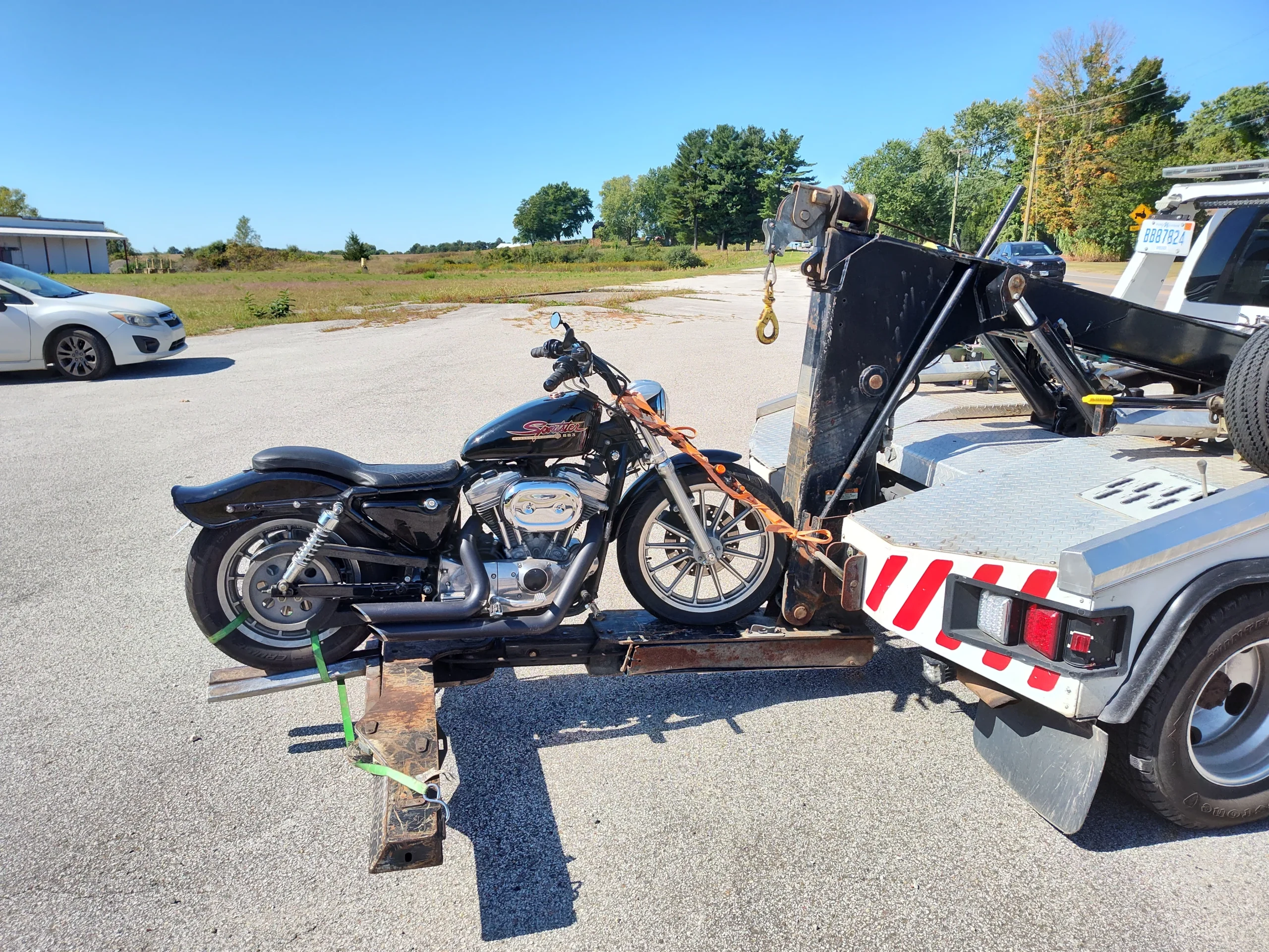 Zielke Towing hauls a Harley Davidson motorcycle using a light duty tow truck on a sunny day