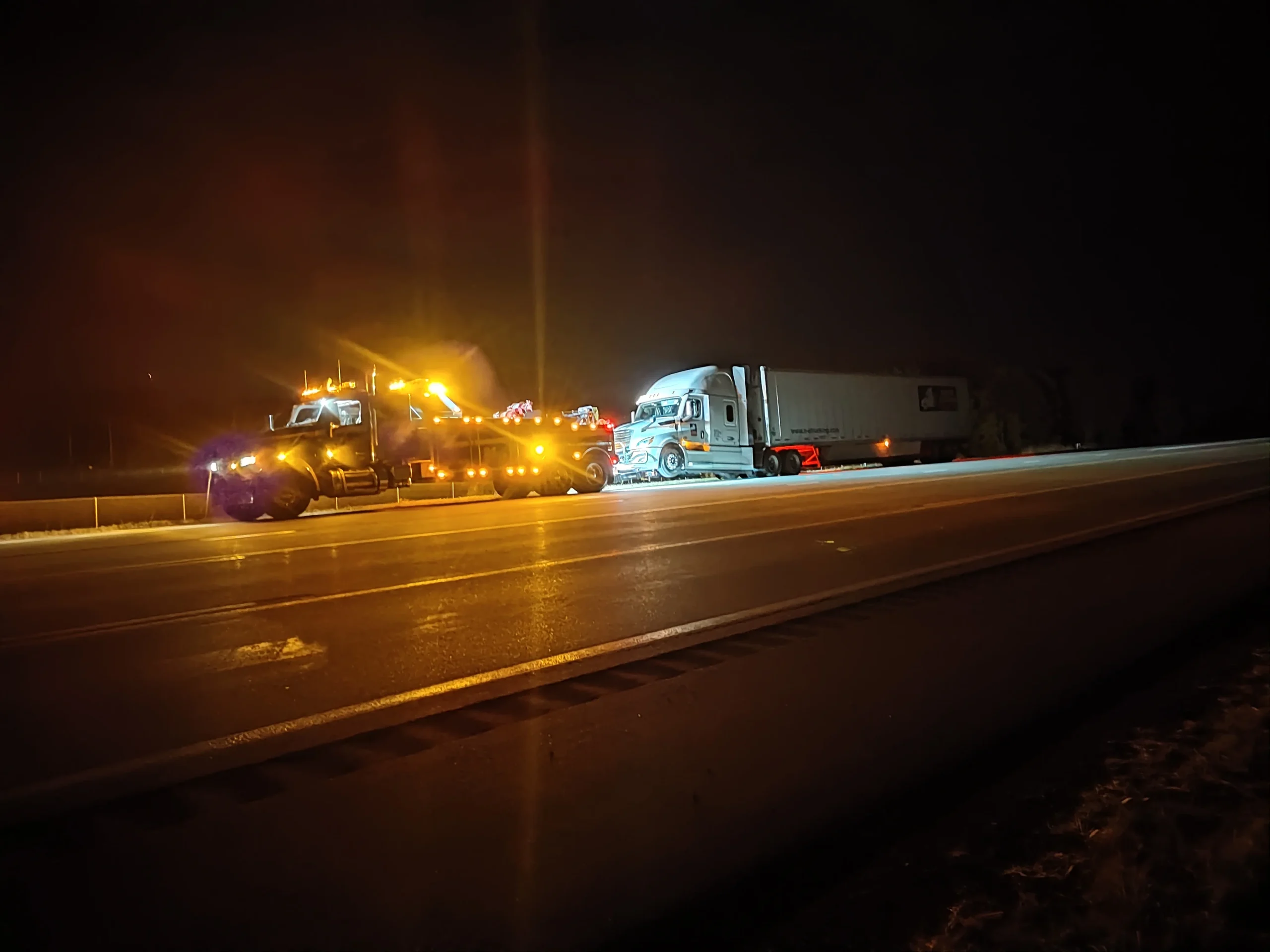 Zielke Towing assisting semi-truck with battery issue on highway at night in Benton Harbor