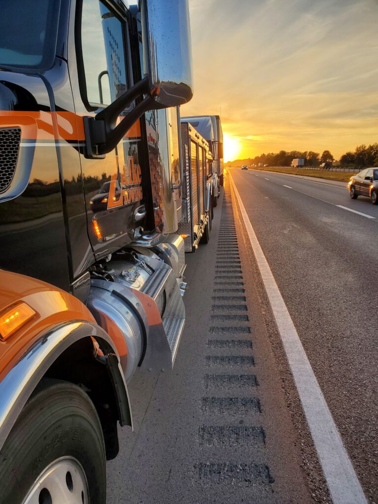 Zielke Towing’s heavy-duty wrecker truck on highway shoulder during a sunset roadside service call